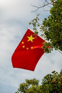 chinese national flag waving amongst trees outdoors