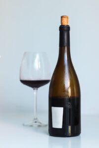 elegant red wine bottle and glass on minimalist background