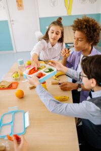 boy in blue long sleeve shirt holding blue and white lunch box