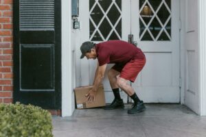 an elderly man leaving a package on the front door